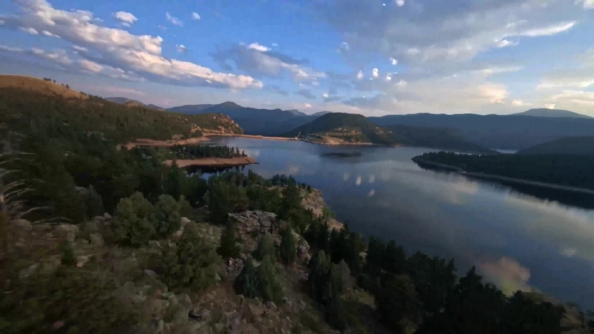 Aerial view of a Colorado mountain reservoir surrounded by pine forest